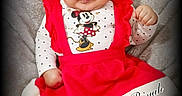 Za'Riyah is registered to the contest to win money with this photo: baby, child, infant, red_dress, christmas_hat, minnie_mouse, polka_dot, leggings, white_fur_trim, fluffy_blanket, portrait, sitting, cute, festive, holiday, expression, face, hat, clothing, indoors
