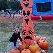 Za'Layah joined the competition — help win amazing prizes! child, pumpkins, face_paint, outdoor, festival, totem_pole, halloween, fall, grass, bounce_house, people, trees, event, costume, fun, smile, orange, black_clothing, playground, celebration