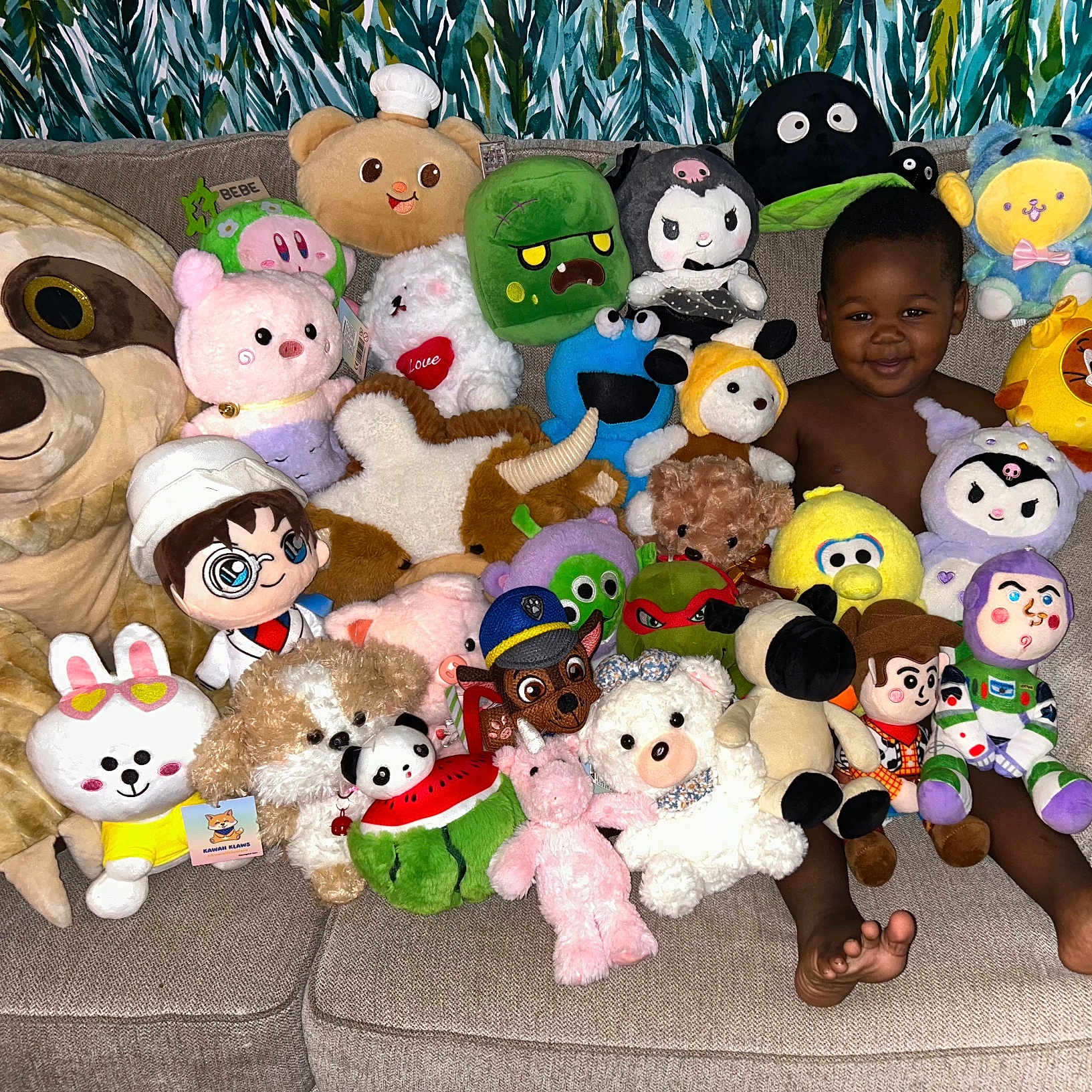 Zaccai is registered to the contest to win money with this photo: child, colorful, couch, cozy, cute, face, feet, furniture, happy, home, indoors, person, playful, plush_toys, relaxing, smiling, sofa, soft_toys, stuffed_animals, toddler