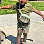 Zaccai joined the competition — help win amazing prizes! child, boy, outdoor, sidewalk, green_shirt, shorts, sandals, crossbody_bag, dinosaur_bag, sunny, grass, curb, shadow, playful, happy, walking, summer, daylight, casual, smiling