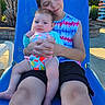 Riley joined the competition — help win amazing prizes! children, baby, infant, older_child, siblings, portrait, smiling, cuddling, sitting, lounge_chair, outdoor, sunny, poolside, palm_trees, vacation, colorful_clothing, blue_chair, family, relaxed, travel_signs