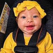 Riley joined the competition — help win amazing prizes! baby, child, car_seat, yellow_clothing, headband, smile, blue_eyes, infant, seatbelt, happy, cute, portrait, safety, closeup, adorable, young_child, infancy, child_safety, bright_colors, face