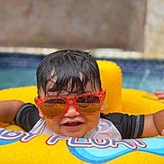Edriel joined the competition — help win amazing prizes! child, pool, water, sunglasses, yellow_float, wet_hair, smiling, summer, outdoor, fun, play, swimming, leisure, happy, kid, toy, vacation, relax, sunny, floating
