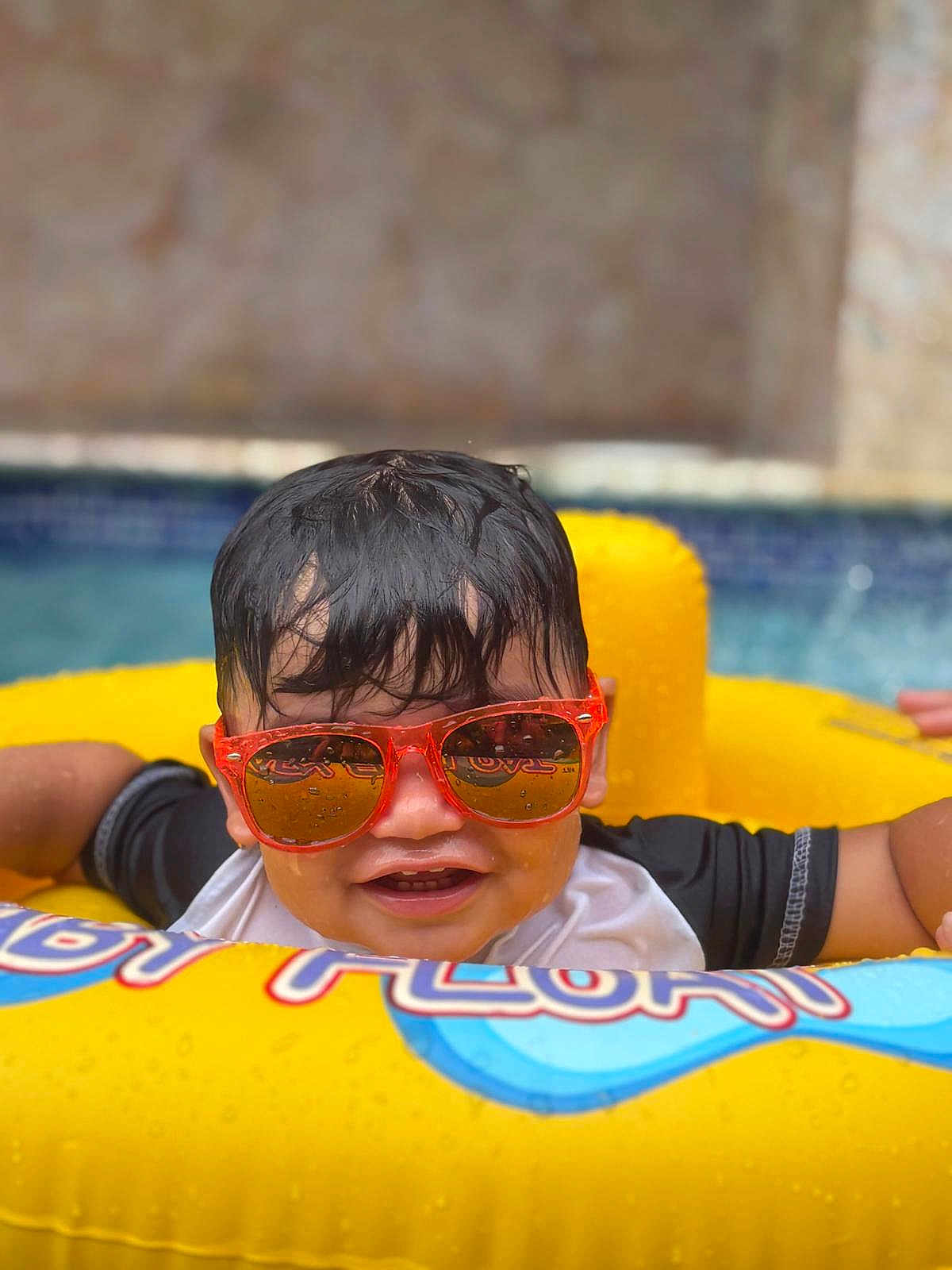 Edriel joined the competition — help win amazing prizes! child, pool, water, sunglasses, yellow_float, wet_hair, smiling, summer, outdoor, fun, play, swimming, leisure, happy, kid, toy, vacation, relax, sunny, floating