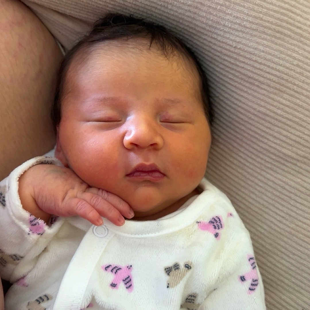 Daphné participe au concours pour gagner de l'argent avec cette photo : baby, newborn, sleeping, infant, onesie, animal_print, hand, face, closed_eyes, soft_texture, cushion, comfort, cozy, resting, cute, peaceful, skin, portrait, indoors, child