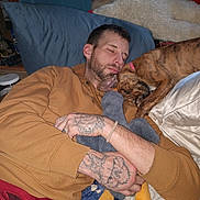 Freya joined the competition — help win amazing prizes! man, adult_male, sleeping, dog, brindle_dog, pet, bed, pillow, blanket, tattoos, hand, beard, cuddle, stuffed_animal, pajamas, bracelet, cozy, indoor, portrait, resting