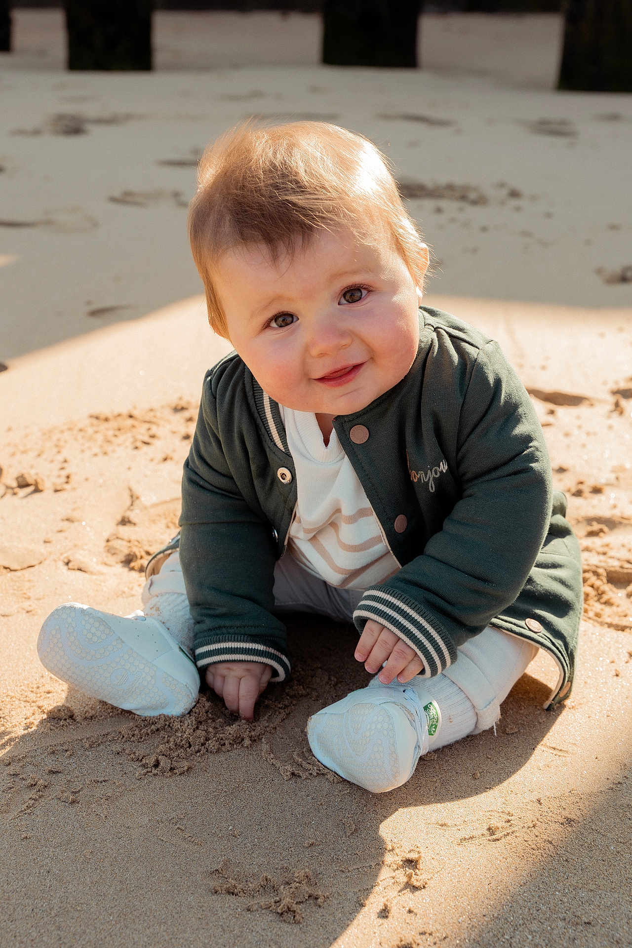 Eden participe au concours pour gagner de l'argent avec cette photo : baby, child, sand, outdoor, smiling, jacket, sneakers, playing, sunlight, cute, portrait, happy, face, hands, clothing, sitting, nature, daylight, infant, casual