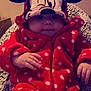 baby, child, onesie, hood, polka_dot, red_clothing, cartoon_face, ears, blanket, cozy, cute, infant, hand, face, portrait, indoor, warm, soft, zipped, seated