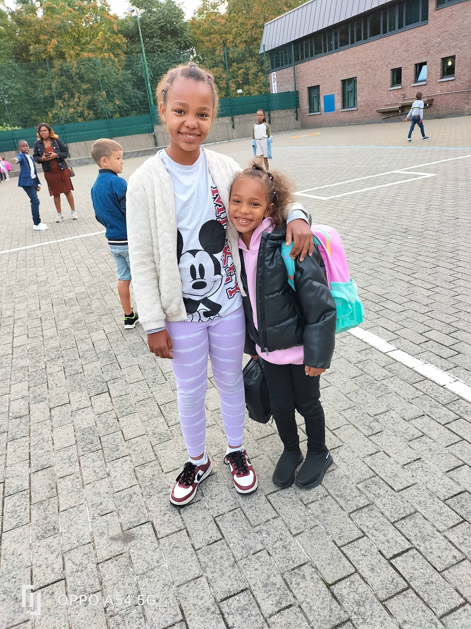 Kadija a rejoint le concours — aidez-le/la à gagner de superbes lots ! asphalt, bag, child, event, fun, gesture, human_settlement, joy, leisure, luggage_and_bags, pedestrian, person, recreation, road_surface, sidewalk, smile, street, tourism, town, travel