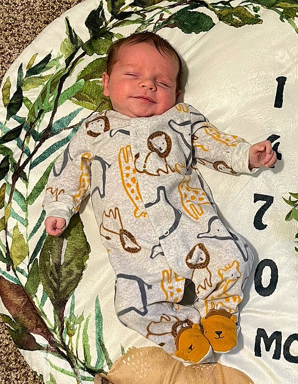 Griffin is registered to the contest to win money with this photo: adaptation, baby, baby_products, baby_toddler_clothing, child, comfort, grass, happy, insect, linens, military_camouflage, musical_instrument, pattern, people_in_nature, person, sleeve, t_shirt, textile, toddler, vertebrate