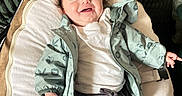 Amaïa participe au concours pour gagner de l'argent avec cette photo : baby, child, smiling, jacket, clothing, lying_down, cushion, hair_clip, cute, happy, indoor, infant, portrait, person, apparel, fabric, young_child, comfortable, expression, face