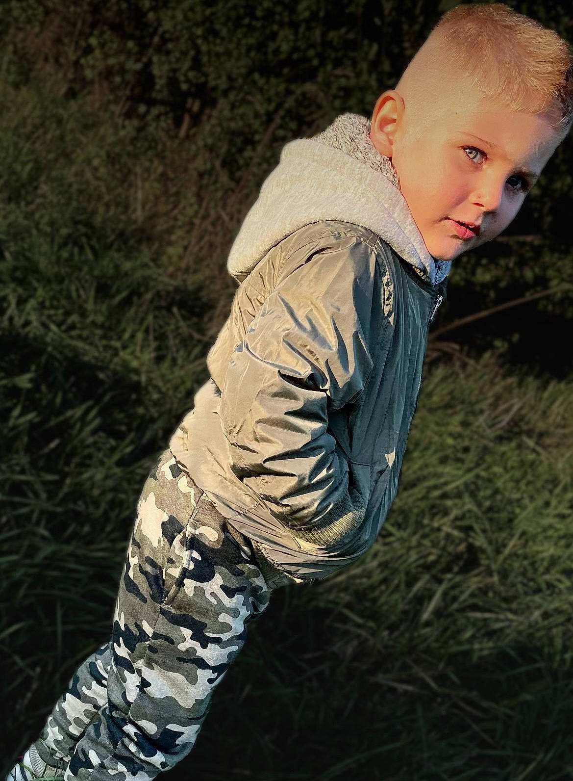 Angélino participe au concours pour gagner de l'argent avec cette photo : baby, child, darkness, flash_photography, fun, fur, grass, grassland, happy, human_body, human_leg, jacket, people_in_nature, person, plant, sitting, sleeve, toddler, tree, winter