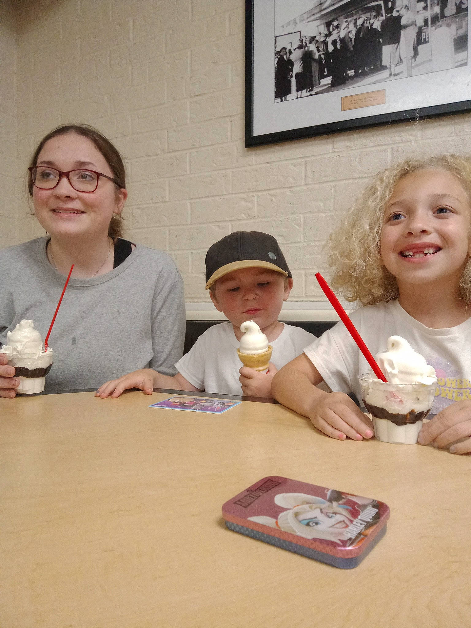 Teegan is registered to the contest to win money with this photo: chair, child, dessert, eating, event, eyewear, fun, glasses, hand, happy, headwear, joy, person, picture_frame, plate, room, sharing, sitting, smile, t_shirt