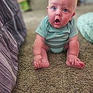 Opie is registered to the contest to win money with this photo: baby, child, surprised, blue_onesie, sitting, carpet, indoor, person, infant, cute, expression, home, floor, furniture, soft_light, blurry_background, skin, head, hands, feet