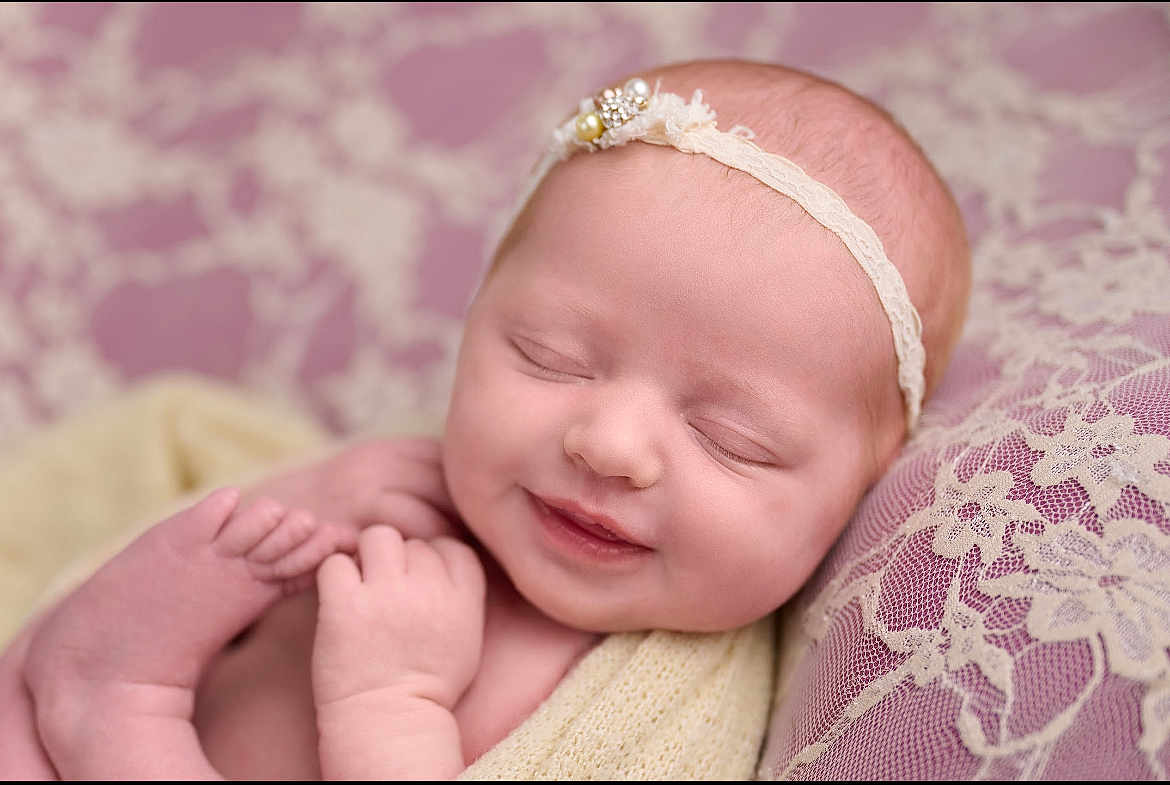 Audi-Kole joined the competition — help win amazing prizes! baby, newborn, smile, sleeping, headband, lace, blanket, cushion, purple, soft_texture, peaceful, infant, portrait, closeup, skin, hands, feet, resting, indoors, cute
