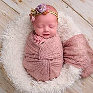 Audi-Kole is registered to the contest to win money with this photo: newborn, baby, sleeping, wrapped, blanket, pink, headband, flower, basket, fluffy, wooden_floor, portrait, soft_texture, cute, peaceful, infant, indoors, closeup, adorable, resting