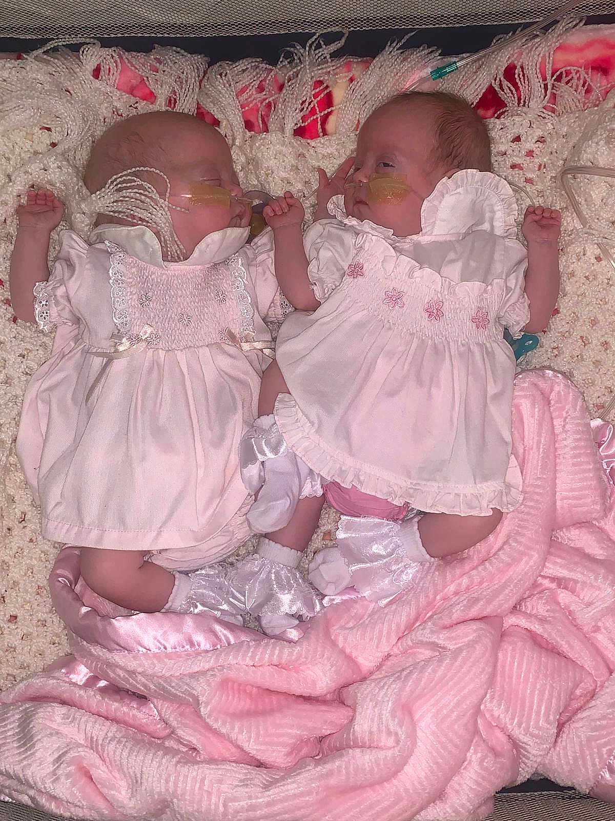 Bonnie Miamie Doyle is registered to the contest to win money with this photo: newborn, baby, infant, pink_dress, socks, blanket, crocheted_blanket, pink_blanket, nasal_tube, medical_care, sleeping, lying_down, cute, twin_babies, indoors, soft_texture, resting, child, person, healthcare