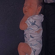 Weston joined the competition — help win amazing prizes! baby, sleeping, infant, onesie, dinosaur_pattern, cozy, resting, child, pajamas, soft_light, indoor, peaceful, cute, newborn, skin, face, head, leg, hand, blanket