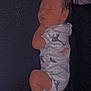 baby, sleeping, infant, onesie, dinosaur_pattern, cozy, resting, child, pajamas, soft_light, indoor, peaceful, cute, newborn, skin, face, head, leg, hand, blanket