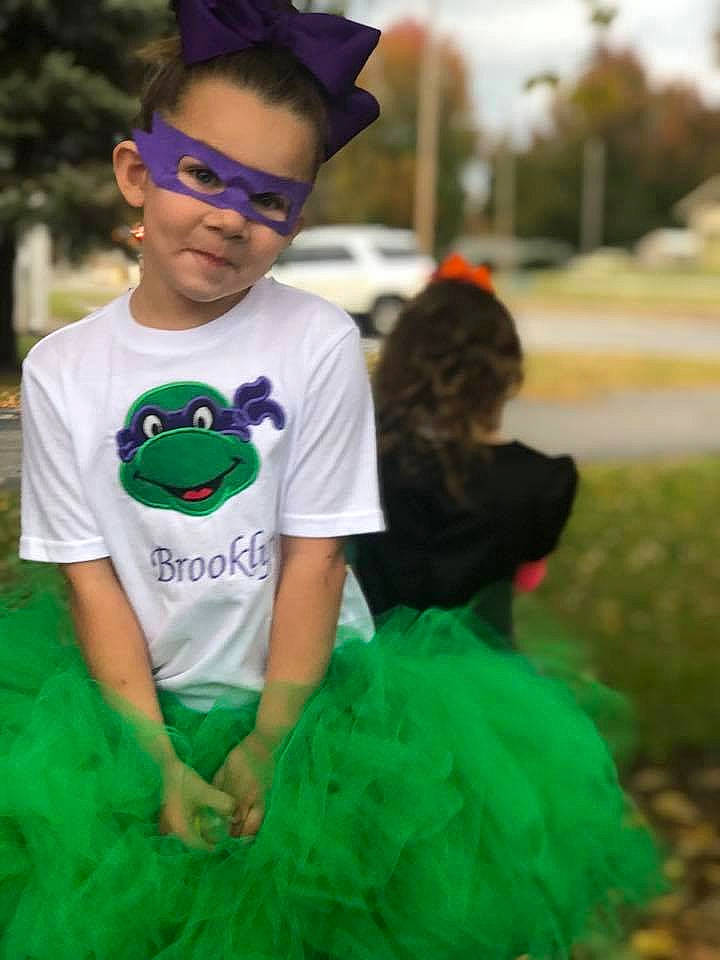 Brooklyn is registered to the contest to win money with this photo: child, clothing, cool, costume, fun, glasses, grass, green, headgear, outerwear, person, product, smile, sunglasses, toddler, vision_care