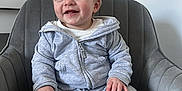 Bentley-James is registered to the contest to win money with this photo: baby, bodypart, clothing, coat, couch, crying, face, finger, furniture, hand, happy, head, jacket, jeans, pants, person, photography, portrait, sad, sitting
