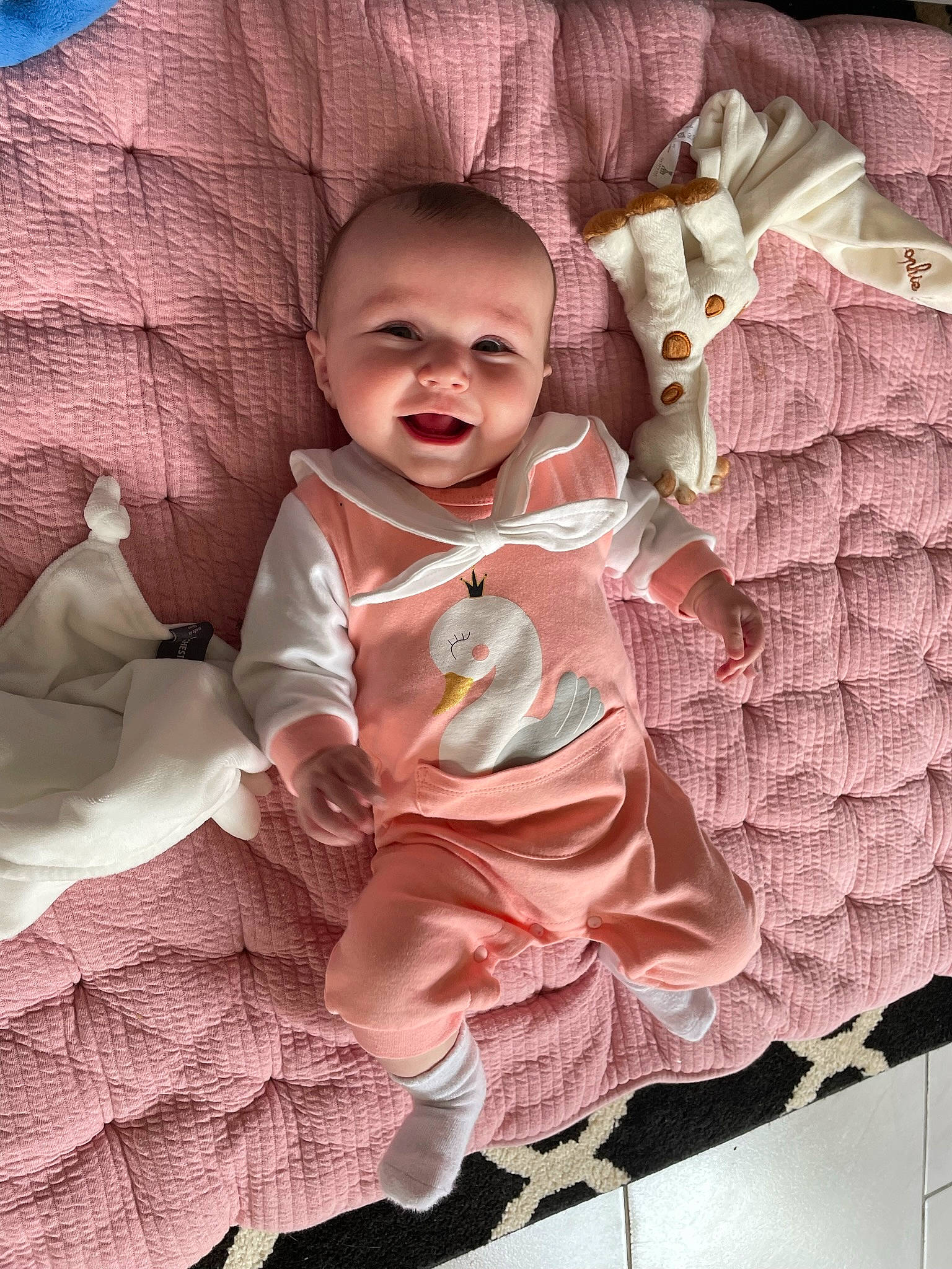 Maëlya participe au concours pour gagner de l'argent avec cette photo : baby, baby_products, baby_toddler_clothing, bedding, cheek, child, comfort, fashion_accessory, headgear, linens, magenta, pattern, peach, person, pink, ruffle, sitting, sleeve, smile, textile