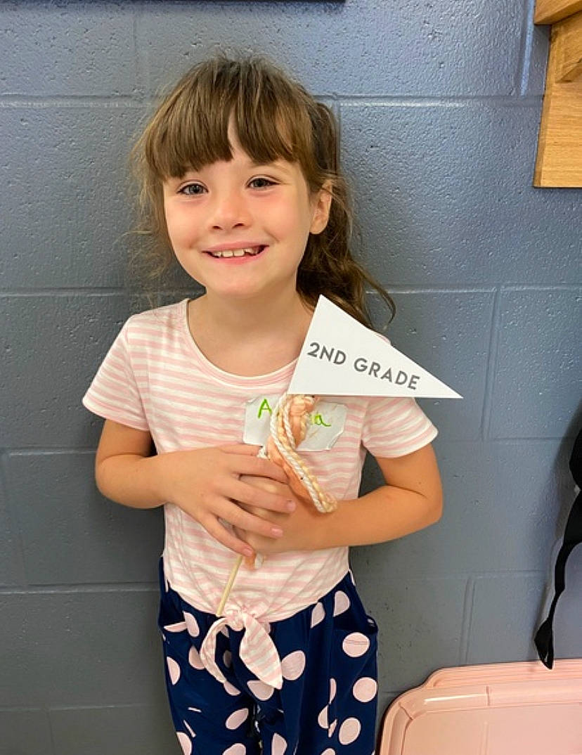 Alana is registered to the contest to win money with this photo: baby_toddler_clothing, bangs, blond, child, dress, face, fun, hair, hairstyle, happy, head, human_body, joy, pattern, person, pink, sleeve, smile, standing, t_shirt