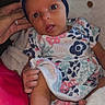 Kinsley joined the competition — help win amazing prizes! baby, infant, child, blue_bow, floral_dress, blanket, hand, foot, tongue_out, wide_eyes, cute, cozy, patterned_clothing, newborn, portrait, indoor, soft_texture, skin, headwear, holding