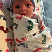 Kinsley is registered to the contest to win money with this photo: newborn, baby, infant, swaddled, blanket, hat, bow, footprint_pattern, hospital, bed, sleeping, cute, small, wrapped, portrait, person, indoors, soft, cozy, child