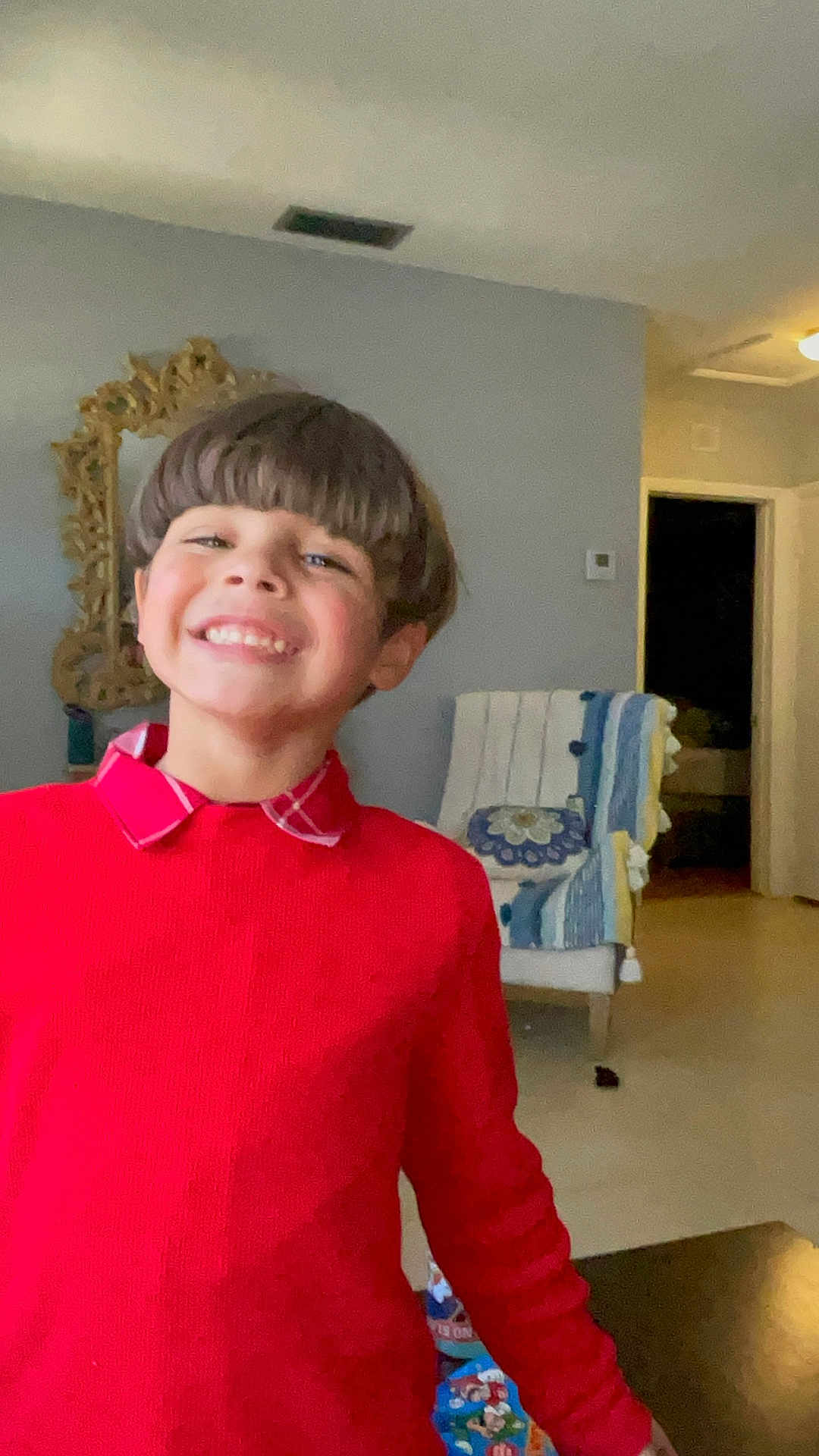 Jayden Noah Barrera joined the competition — help win amazing prizes! child, smile, red_sweater, indoor, haircut, face, happy, person, plaid_collar, mirror, chair, decor, home, furniture, portrait, young, boy, clothing, expression, casual