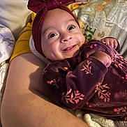 Adalynn joined the competition — help win amazing prizes! baby, smiling, headband, floral, outfit, arm, blanket, person, face, happy, infant, closeup, indoors, cozy, parent, child, cute, tender, warm, soft_lighting