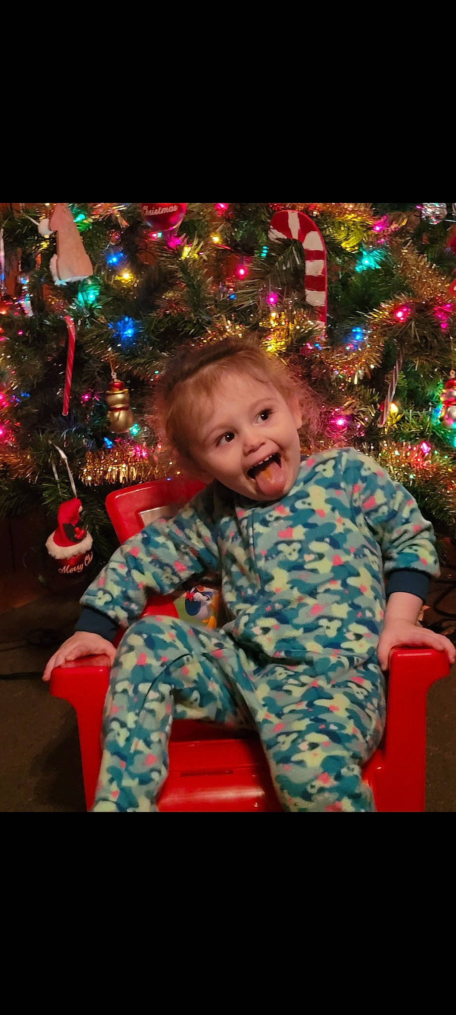 Amberlynn is registered to the contest to win money with this photo: baby_toddler_clothing, cheek, christmas, christmas_decoration, christmas_ornament, christmas_tree, event, eye, facial_expression, fun, happy, head, holiday, human, human_body, light, ornament, person, smile, standing
