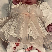 Haïley a rejoint le concours — aidez-le/la à gagner de superbes lots ! baby, infant, child, dress, lace, bow, headband, socks, cushion, soft_fabric, smile, portrait, indoors, cute, sitting, comfortable, clothing, accessories, white, red