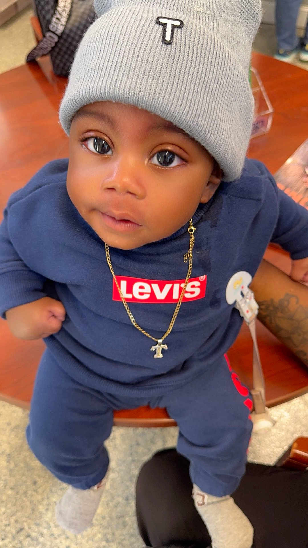 Truce joined the competition — help win amazing prizes! toddler, child, beanie, hat, necklace, gold_chain, levis, clothing, indoor, table, person, face, cute, socks, sitting, looking_up, floor, hand, tattoo, casual_wear