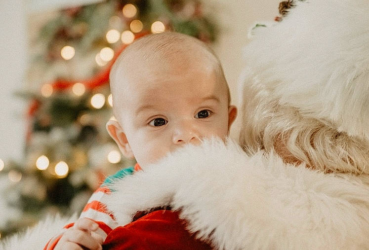 Anderson is registered to the contest to win money with this photo: baby, baby_toddler_clothing, child, christmas, christmas_eve, christmas_tree, comfort, conifer, event, eye, fun, fur, happy, holiday, ornament, person, portrait_photography, santa_claus, sitting, toddler