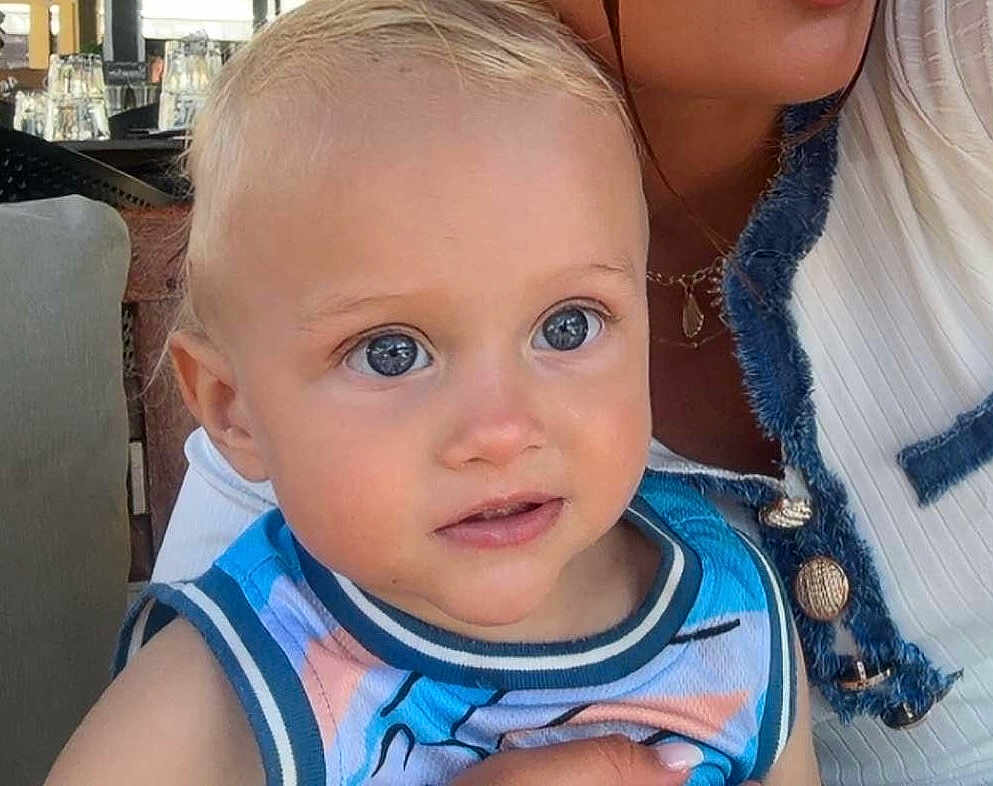 Vicenzo participe au concours pour gagner de l'argent avec cette photo : toddler, child, baby, face, blue_eyes, blond_hair, sleeveless_shirt, person, portrait, indoor, holding, adult, closeup, cute, young_child, human, skin, expression, looking_away, casual_clothing