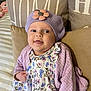 baby, child, portrait, face, smile, hat, beret, flower, purple, cardigan, dress, floral, couch, pillow, indoor, cute, infant, happy, person, cozy