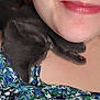 kitten, cat, sleeping, person, shoulder, close_up, smile, floral_clothing, skin, nap, black_cat, resting, cute, animal, pet, young_cat, indoor, soft_light, head, face_partial