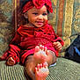 Zaniyah joined the competition — help win amazing prizes! baby, child, couch, cozy, cute, feet, foot, happy, headband, home, indoor, patterned_fabric, person, portrait, red_clothing, relaxed, sitting, smile, toddler, young_child