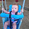 baby, child, infant, swing, playground, outdoor, patio, seated, smiling, wide_eyed, purple_clothing, blue_swing, safety_harness, ropes, hands, portrait, daylight, concrete, backyard, playtime