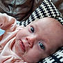 baby, infant, face, closeup, pink_clothing, blue_eyes, drool, pillow, patterned_pillow, leather_couch, indoor, person, child, cute, young, portrait, skin, head, expression, resting
