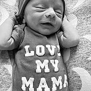 Cayden joined the competition — help win amazing prizes! baby, newborn, infant, smiling, hat, beanie, clothing, onesie, text_on_clothing, blanket, pattern, moon_pattern, lying_down, cute, sleepy, black_and_white, portrait, close_up, small_hands, peaceful