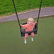 Oaklynn-Ayla is registered to the contest to win money with this photo: toddler, child, swing, playground, grass, outdoor, happy, smiling, pink_clothing, socks, chain, seat, fun, daylight, nature, park, greenery, person, recreation, activity