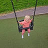 toddler, child, swing, playground, grass, outdoor, happy, smiling, pink_clothing, socks, chain, seat, fun, daylight, nature, park, greenery, person, recreation, activity