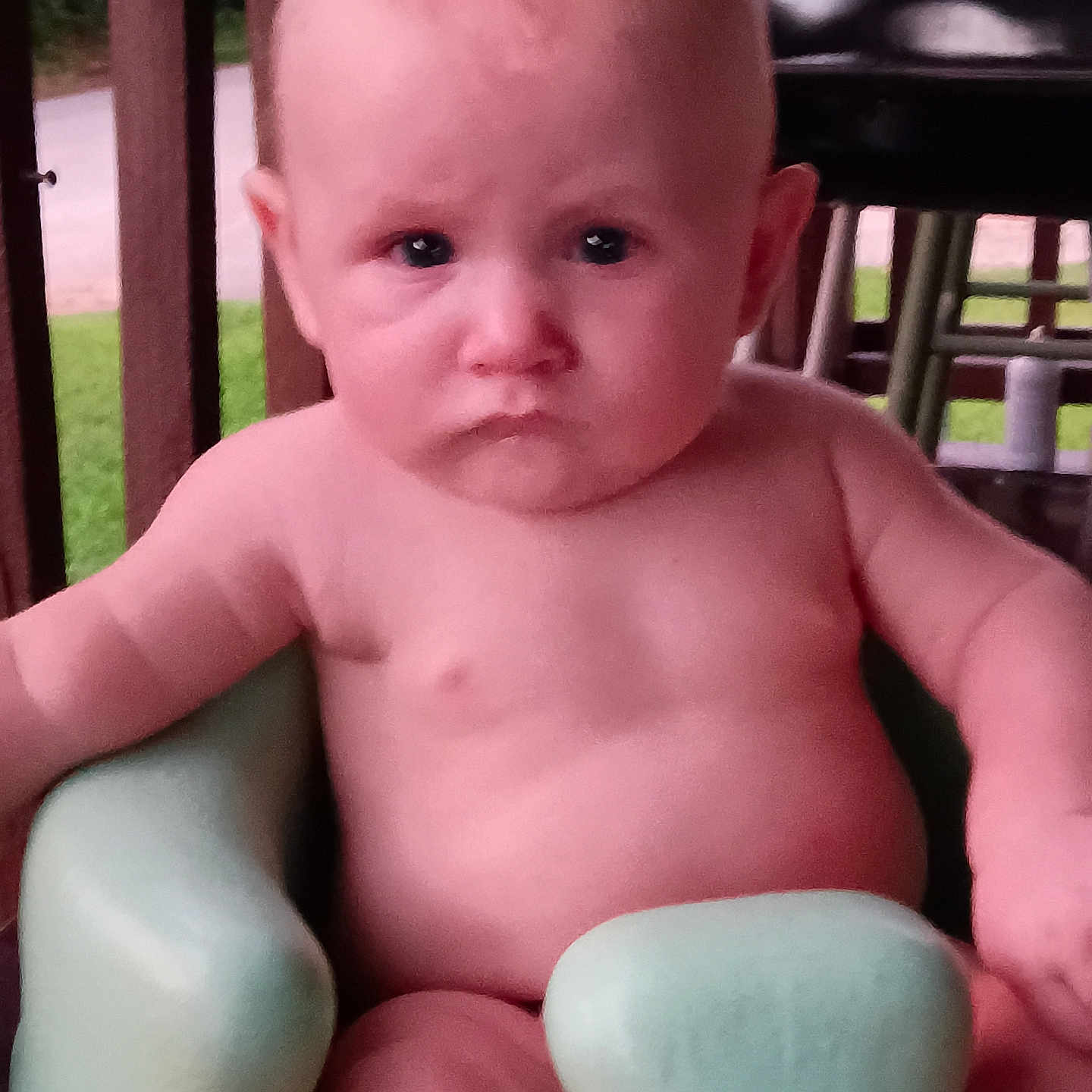 Ashton joined the competition — help win amazing prizes! baby, child, infant, porch, green_chair, serious_expression, skin, sitting, outdoor, wooden_railings, face, person, young, head, arm, legs, nature, daylight, closeup, cute