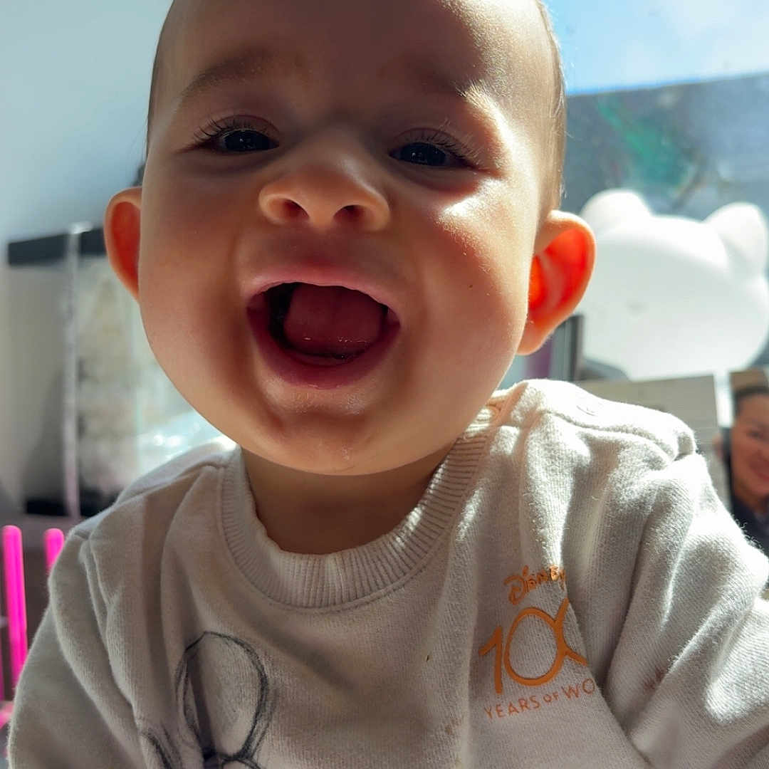 Marwan a rejoint le concours — aidez-le/la à gagner de superbes lots ! toddler, child, smile, happy, indoor, sunlight, window, blue_sky, sweatshirt, mickey_mouse, clothing, face, expression, person, portrait, cute, young_child, casual, daylight, joy