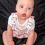 Willow joined the competition — help win amazing prizes! baby, infant, child, pink_overalls, white_shirt, sitting, black_fabric, wooden_sign, 5_months, hands, feet, expression, surprised, face, blue_eyes, head, skin, cute, indoor, portrait
