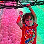 Ezra is registered to the contest to win money with this photo: child, kid, boy, red_tshirt, spiderman, ball_pit, plastic_balls, rope_net, indoor_play_area, playground, colorful_lighting, curly_hair, casual_clothing, fun, active, smiling, portrait, hanging, leisure, amusement