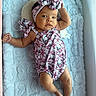 baby, infant, crib, blanket, headwrap, hello_kitty, clothing, soft_texture, lying_down, cute, face, person, indoors, infant_clothing, child, resting, newborn, comfortable, portrait, sleep_area