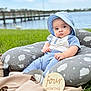 baby, infant, blue_clothing, sunhat, pillow, cloud_pattern, grass, outdoor, lake, pier, windmill, wooden_sign, four_months, milestone, cute, portrait, child, sitting, blanket, nature